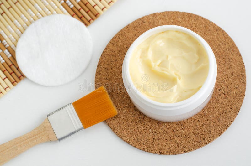 Yellow facial mask banana face cream, hair mask, body shea butter in the small white jar. Natural skin and hair concept. Top view, copy space royalty free stock photos Yellow facial mask banana face cream, hair mask, body shea butter in the small white jar. Natural skin and hair concept. Top view, copy space royalty free stock photos