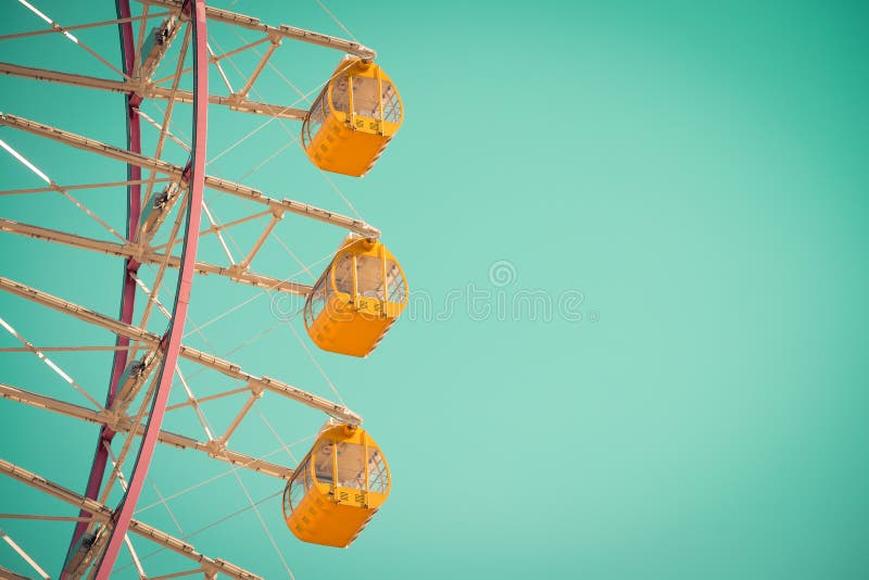 Beautiful yellow ferris wheel on blue sky - Vintage tone