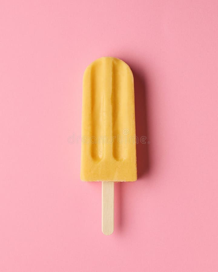 Yellow fruit popsicle on pink background, top view. Mango, passion fruit and pineapple flavor