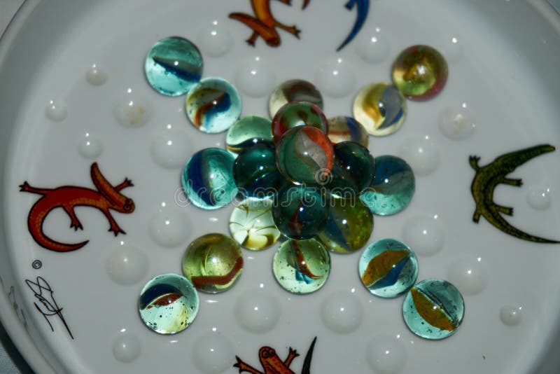 Yellow, Green, Blue and Red Glass Marbles on a Table Stock Photo