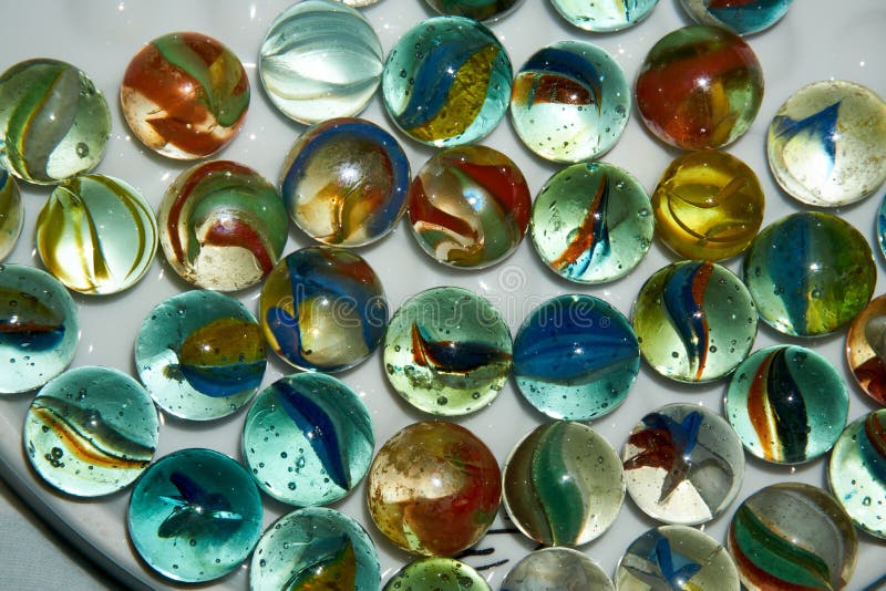 Yellow, Green, Blue and Red Glass Marbles on a Table Stock Photo