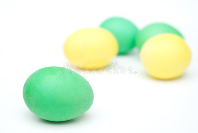 Yellow and green Easter eggs isolated on white