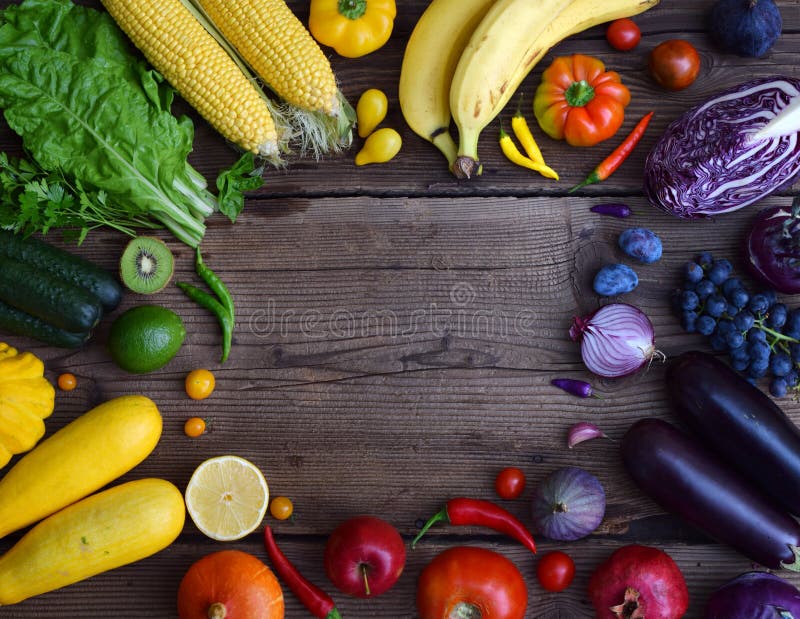 yellow, green, orange, red, purple fruits and vegetables on wooden background. Healthy food. Multicolored raw food. Copy space