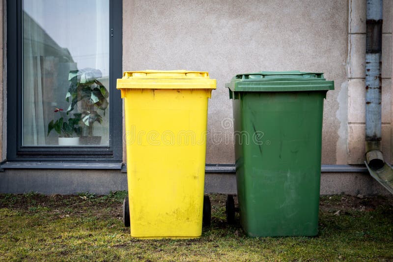Yellow and Green Trash Bins Next to Building royalty free stock image