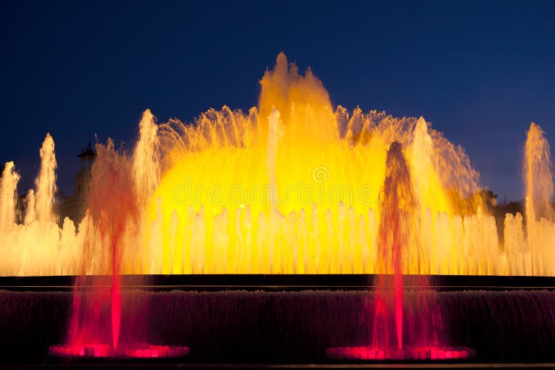 Yellow Illuminated Fountain in the Evening Light of Barcelona Stock