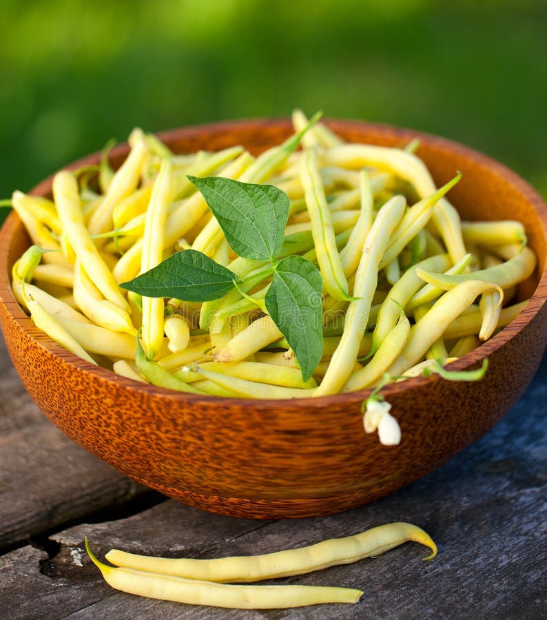 Yellow kidney beans in a bowl on wooden table