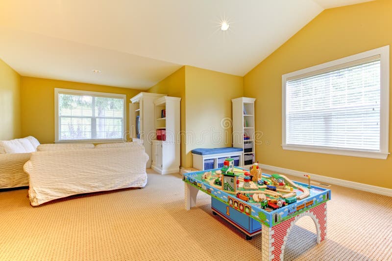 I bambini sala giochi con divano bianco e pareti color senape.