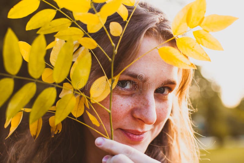 Yellow leaf on the female face in the park stock photography Yellow leaf on the female face in the park stock photography