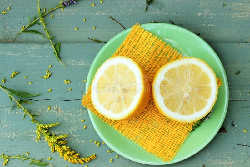 Yellow lemon on green wooden table with some floral details stock images Yellow lemon on green wooden table with some floral details stock images
