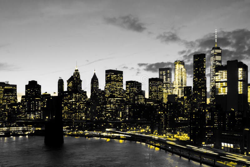 Yellow lights of the downtown New York City skyline buildings in black and white cityscape