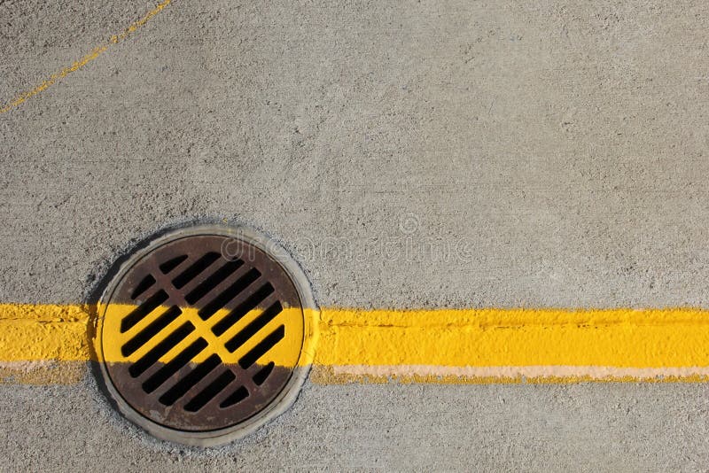 Yellow line across drain cover stock photo