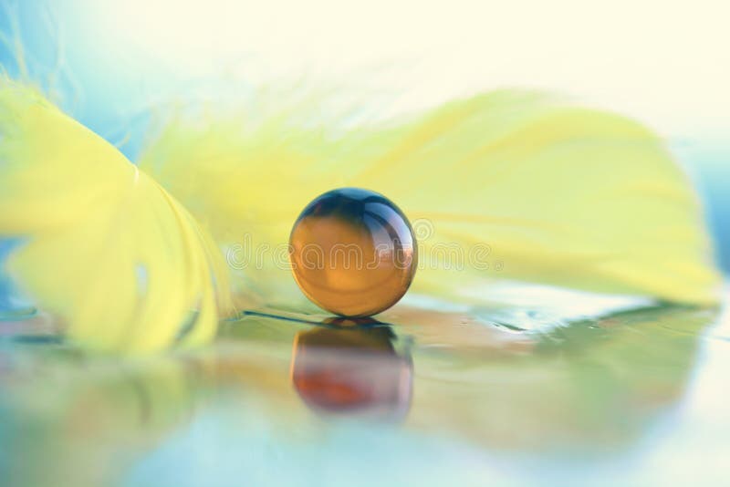 Yellow Marble Ball and Feathers Stock Photo Image of purity, light