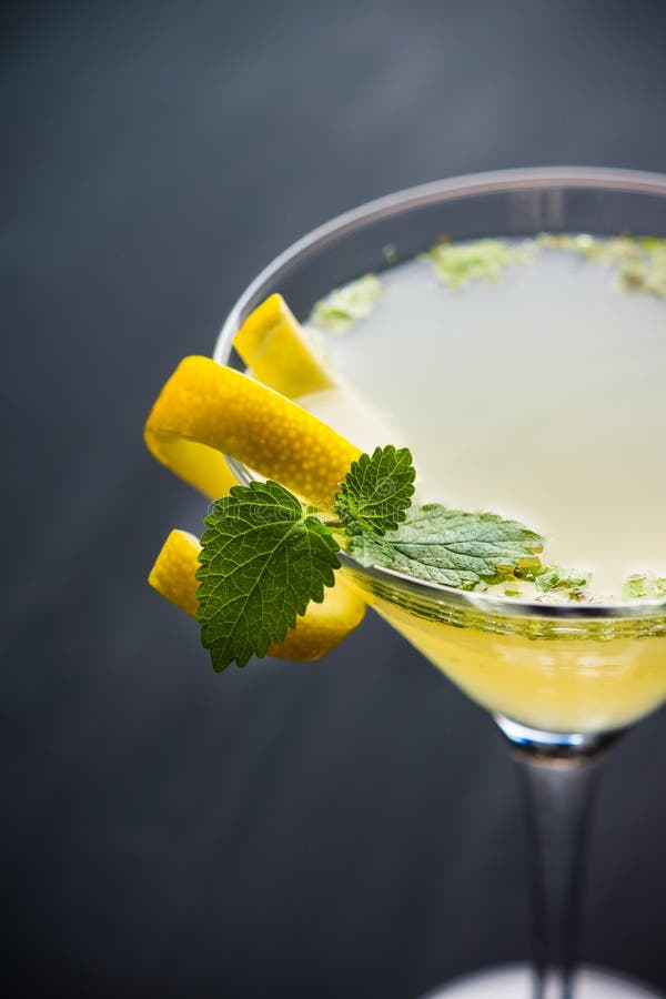 Yellow martini cocktail with lemon and mint