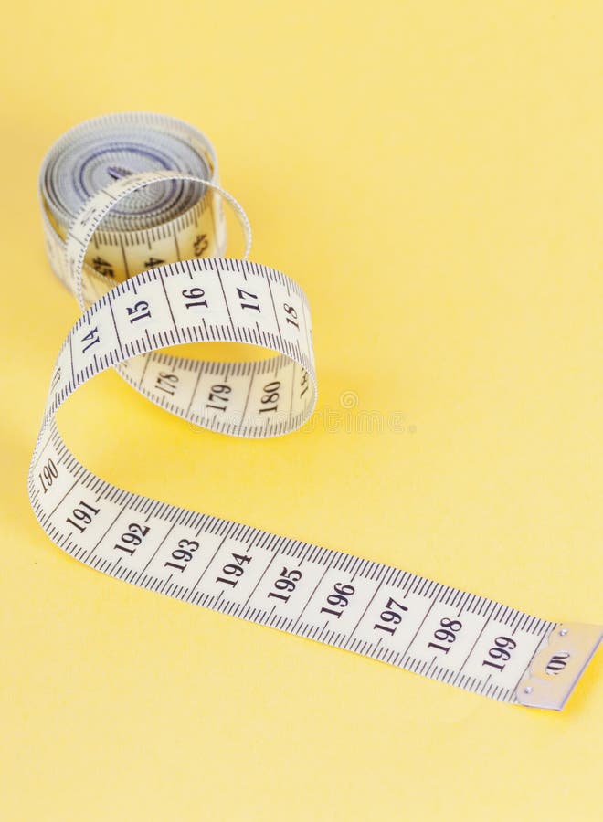 Yellow measuring tapes stock photo. Image of measurement 26103808