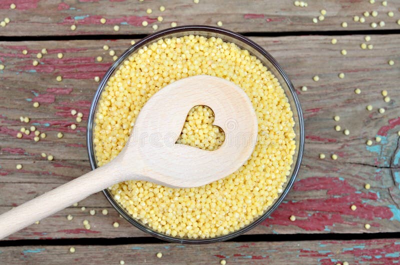 Yellow millet groats in bowl stock photos