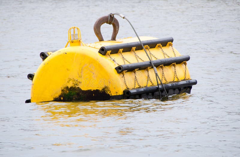 Yellow mooring buoy at sea with navigation light