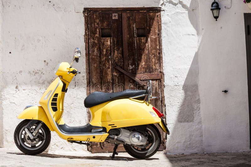 Yellow motorbike in front of house antique wooden door