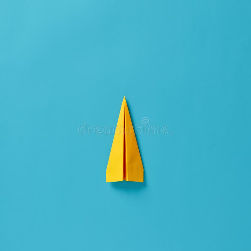 Yellow Paper Airplane on Blue Background. Top View Stock Photo Image