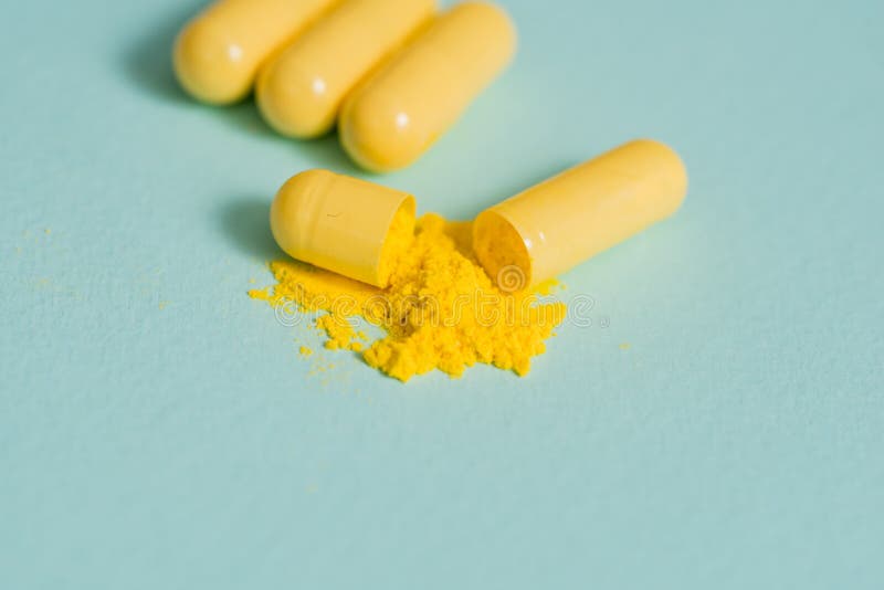 Yellow pills and capsules on a blue background. 