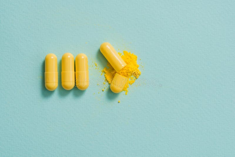 Yellow pills and capsules on a blue background. 