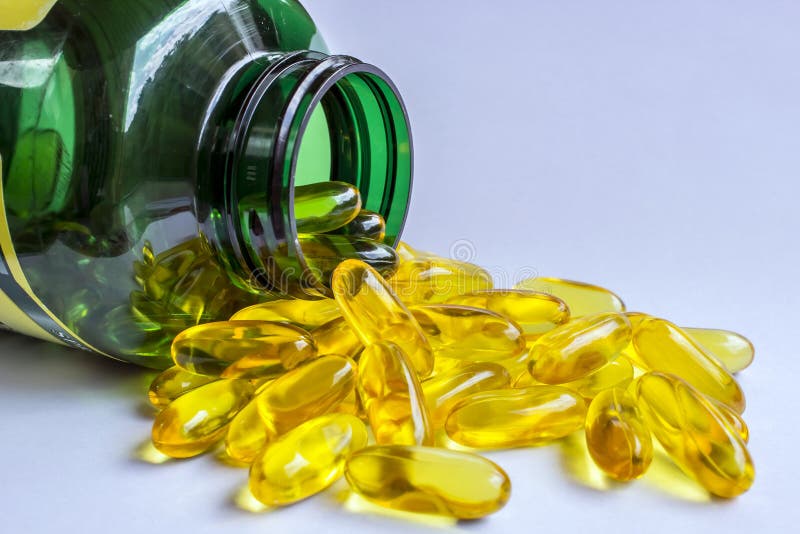 Yellow Pills Outside Its Green Bottle stock images