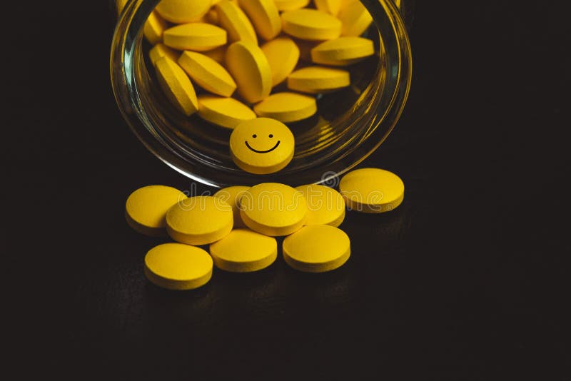 yellow pills spilling out of a toppled pill bottle - a smiley face pill - anti depression concept royalty free stock photos yellow pills spilling out of a toppled pill bottle - a smiley face pill - anti depression concept royalty free stock photos