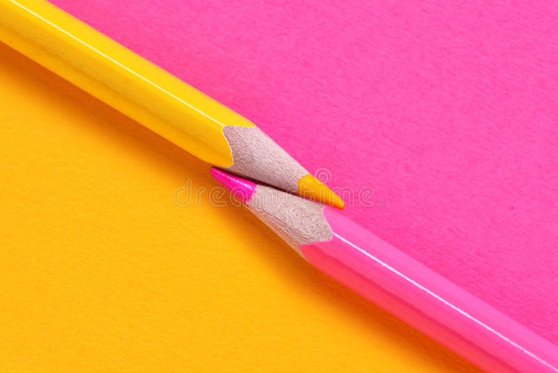 Yellow and Pink Crayons on the Paper Background Stock Photo
