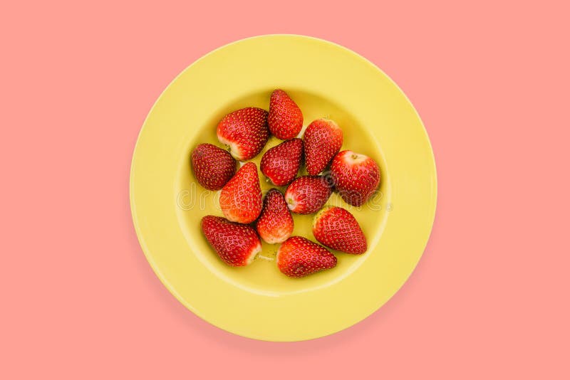 Yellow plate with strawberries on a bright background. Ripe strawberries, red color in a yellow plate. Healthy food, a