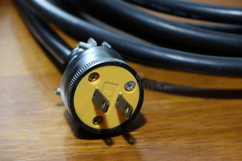 Yellow plug with black cable on the wooden floor. stock photography Yellow plug with black cable on the wooden floor. stock photography