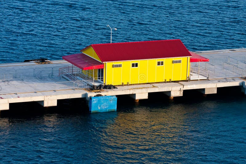 Yellow and Red Building on Pier Over Blue Water