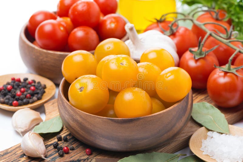 Yellow and red cherry tomatoes in wooden bowls, close-up