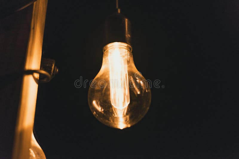 Yellow retro incandescent bulbs hang in the evening at a party. Light bulbs hanging on a wooden bridge at night royalty free stock image Yellow retro incandescent bulbs hang in the evening at a party. Light bulbs hanging on a wooden bridge at night royalty free stock image