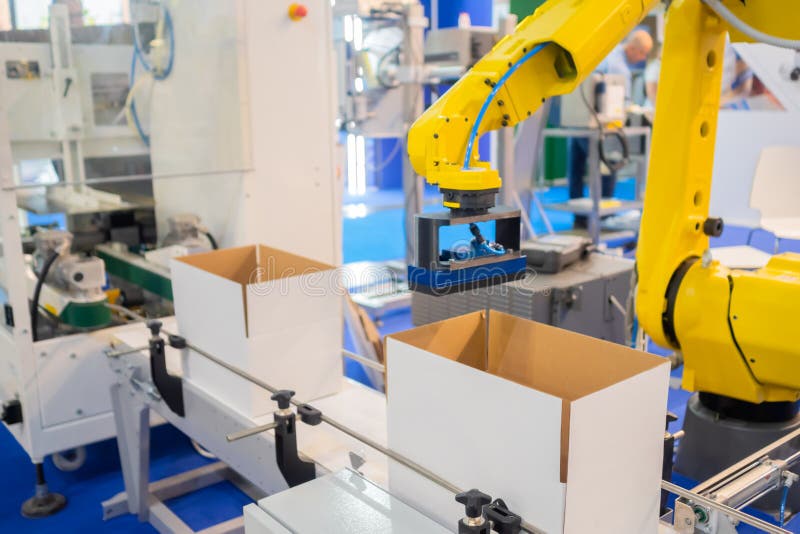 Yellow robotic arm manipulator working with cardboard boxes - sorting system stock photo