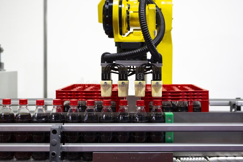 Yellow robotic arm soda bottles royalty free stock image