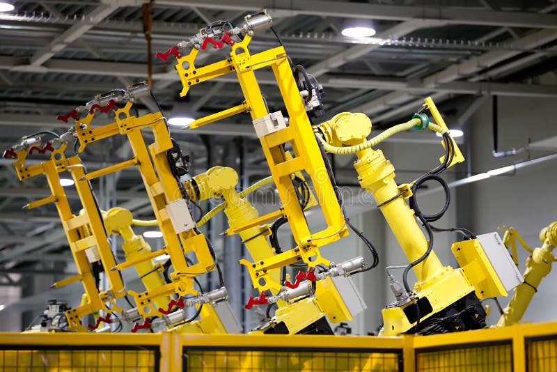 Yellow robots on a production line stock photography