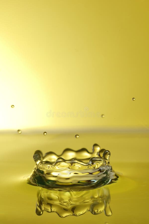 Splashing water droplet over yellow background, high speed photography. Splashing water droplet over yellow background, high speed photography.