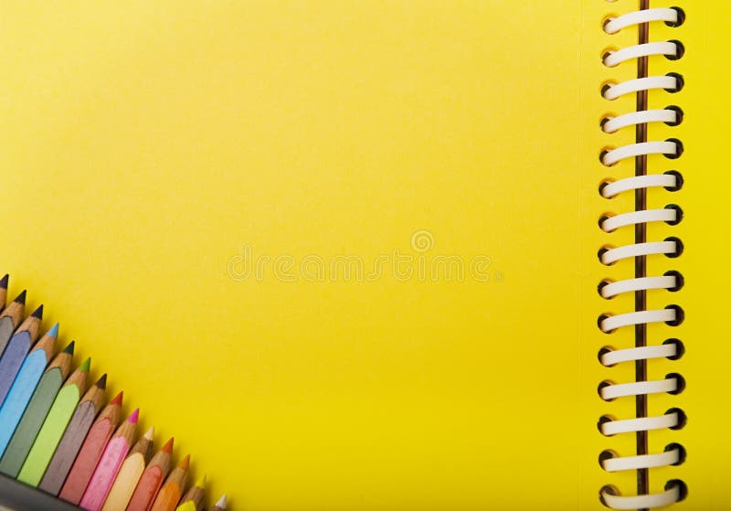 Yellow spring notebook and crayons in a corner.