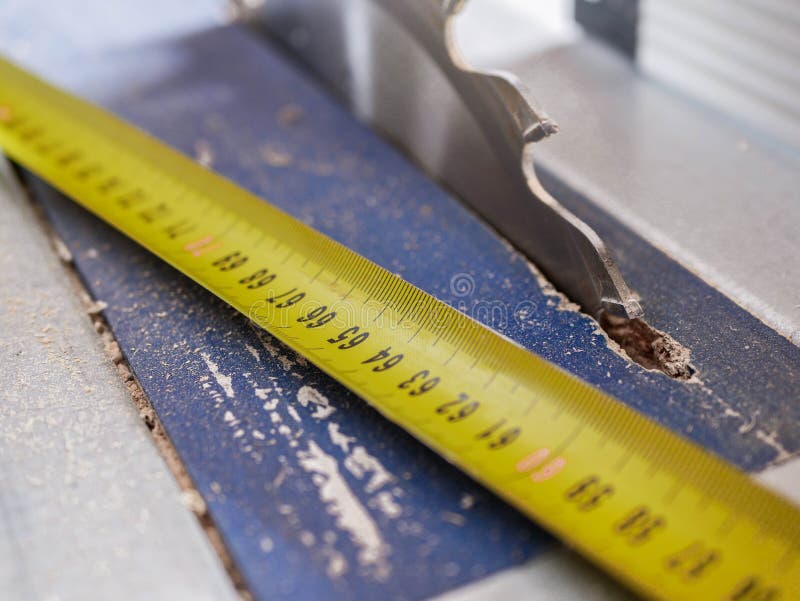 Yellow tape measurer on dusty circular saw, royalty free stock photo Yellow tape measurer on dusty circular saw, royalty free stock photo