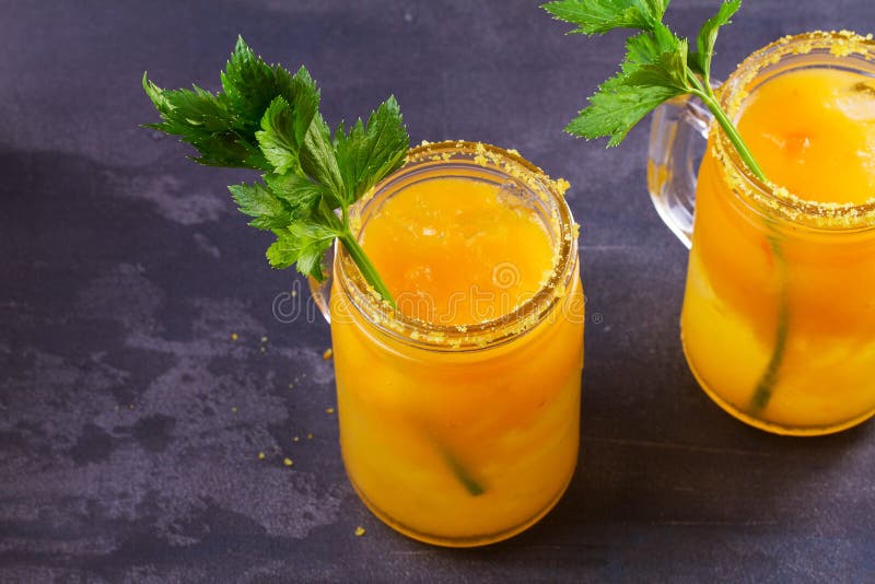 Yellow Tomato Cocktail with Celery, Spices, Salt and Ice. Stock Image