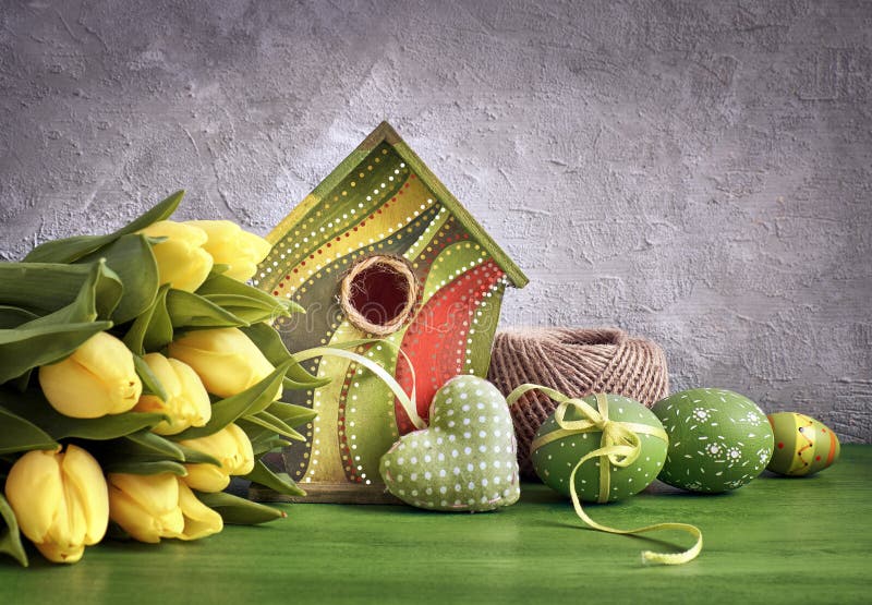 Yellow tulips, birdhouse and painted Easter eggs with stuffed he royalty free stock images