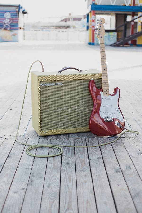 Yellow vintage guitar aplifier with cable and red electric guitar royalty free stock photography Yellow vintage guitar aplifier with cable and red electric guitar royalty free stock photography