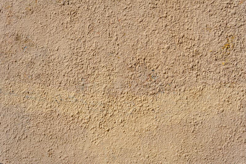 A yellow wall covered with numerous layers of plaster and paint. royalty free stock photography