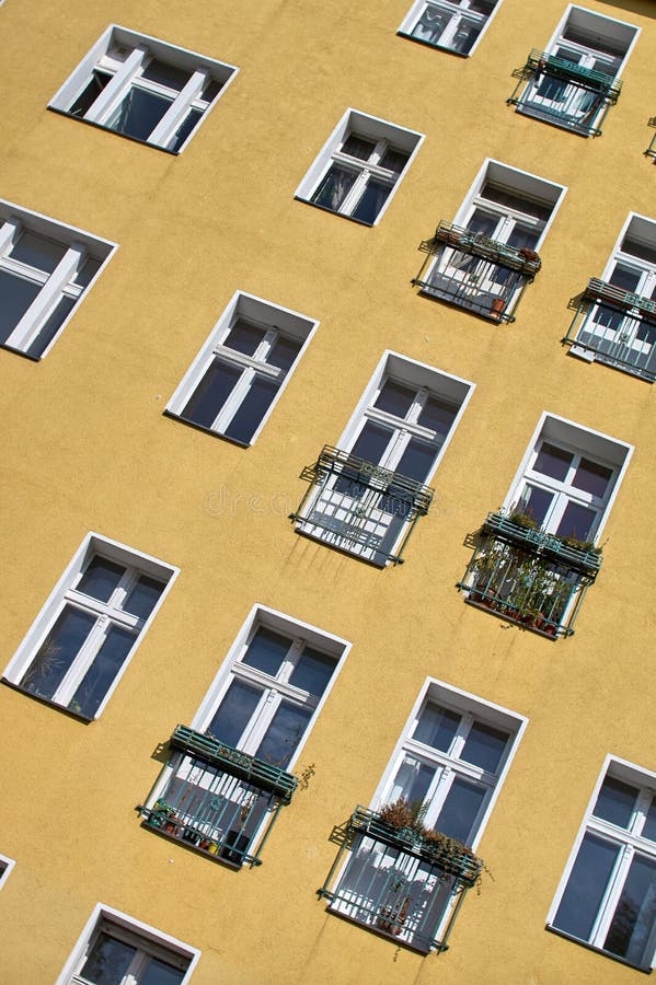 The Yellow Wall of the House with Windows and Small Balconies Stock