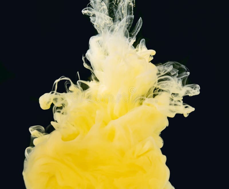 Yellow-white smoke of acrylic paint swirling in liquid, isolated on black b...