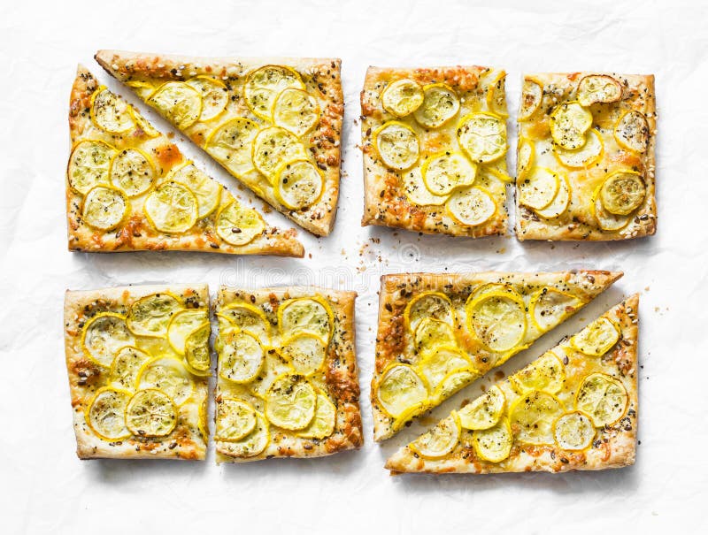 Yellow zucchini puff pastry mini tarts on a light background, top view. Tasty snack, tapas royalty free stock image