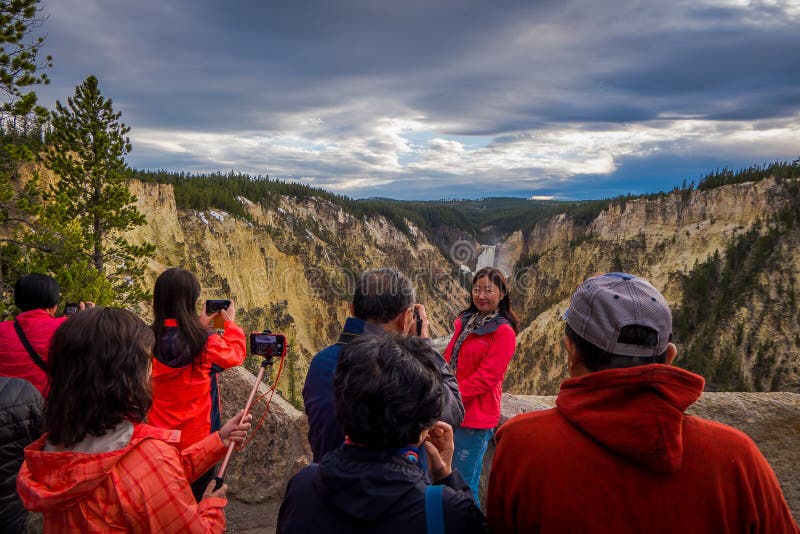 YELLOWSTONE NATIONAL PARK, WYOMING, USA - JUNE 07, 2018: Unidentified tourists taking pictures of the beautiful upper fall in Yellowstone National Park, Wyoming in USA.