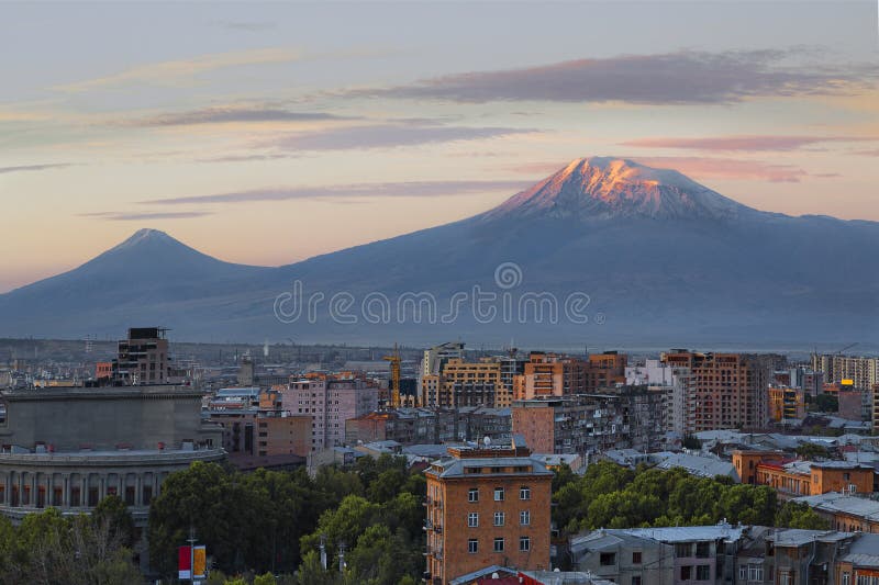 Yerevan huvudstad av Armenien på soluppgången med de två maxima av Mountet Ararat på bakgrunden royaltyfri fotografi Yerevan huvudstad av Armenien på soluppgången med de två maxima av Mountet Ararat på bakgrunden royaltyfri fotografi
