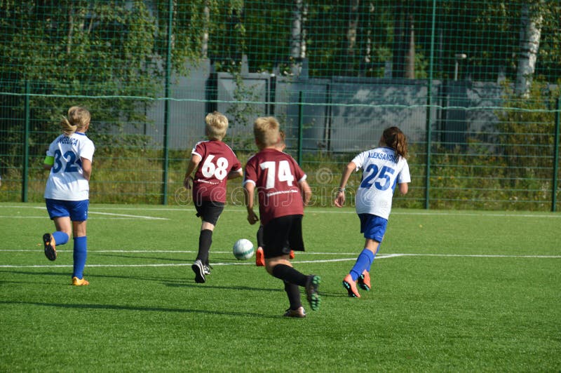 Yngre fotbollsmatch, kvinnlig och manliga spelare på fältet arkivfoton Yngre fotbollsmatch, kvinnlig och manliga spelare på fältet arkivfoton