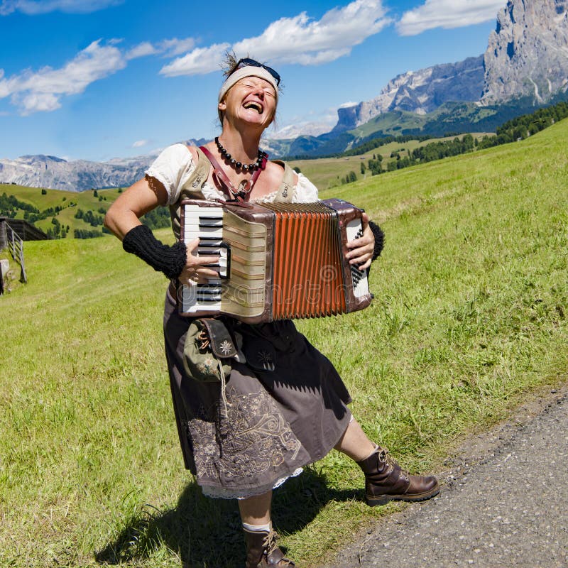 Yodelling musician with flowers in hair and garb in front of Dolomites, South Tyrol, Italy. Yodelling musician with flowers in hair and garb in front of Dolomites, South Tyrol, Italy