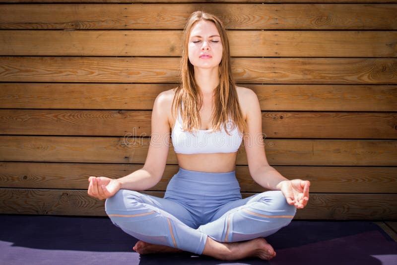 Yoga de pratique de belle jeune femme à l'intérieur image stock Yoga de pratique de belle jeune femme à l'intérieur image stock